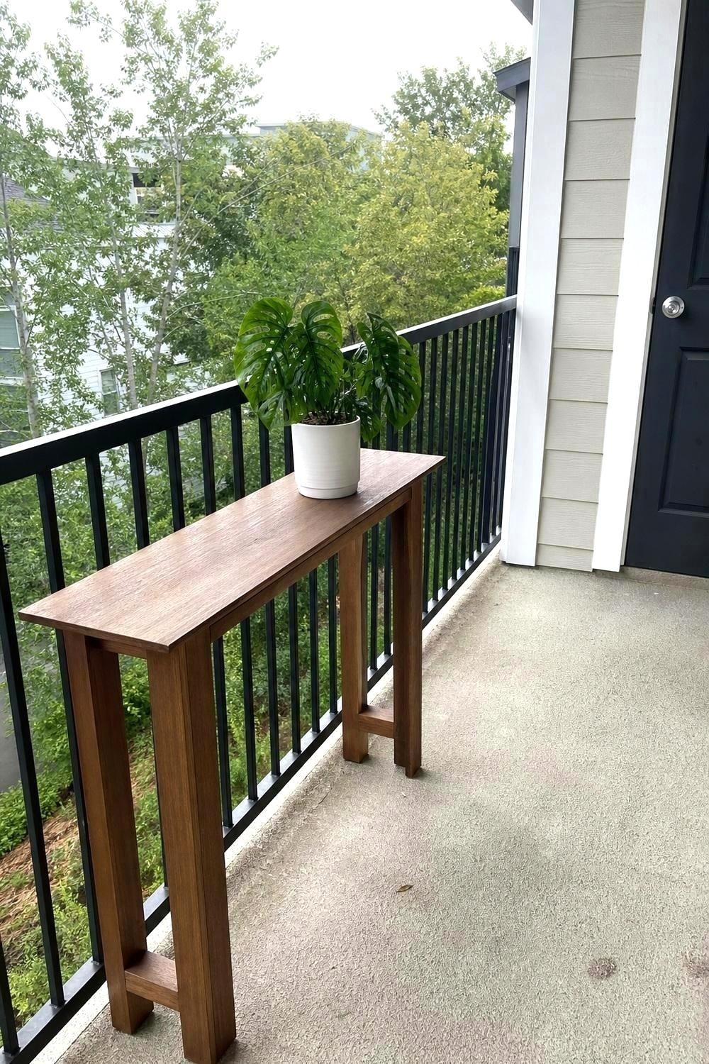 Drop-leaf wall mount table folded flat against a balcony wall on its folding hinge