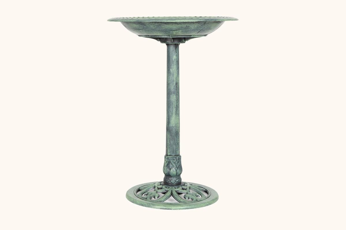 A metal pedestal bird bath