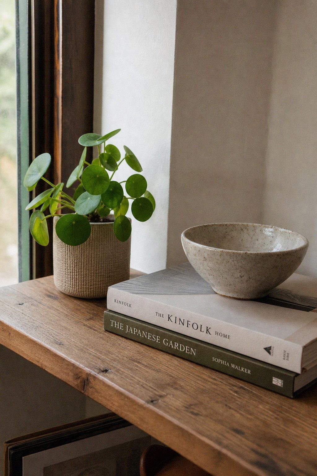 Warm lamp light casting a soft shadow across a styled corner shelf in the evening