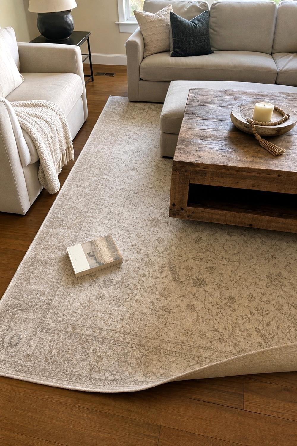 Beige washable area rug under a coffee table in a living room