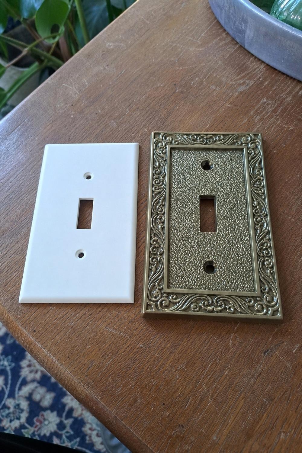 hand unscrewing a white switch plate cover with a screwdriver before installing a new one