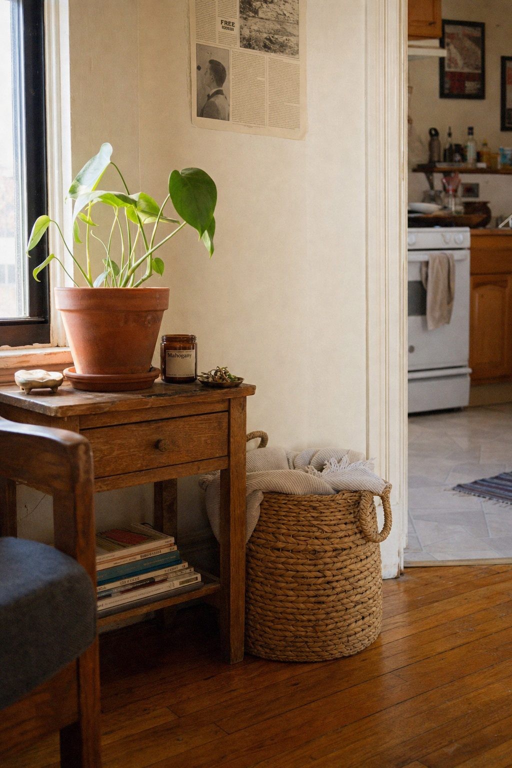 A woven rattan basket holding a folded blanket beside a wood side table