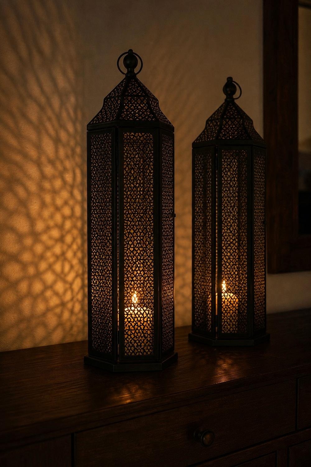 Two tall black metal lanterns flanking a dark Halloween table setting