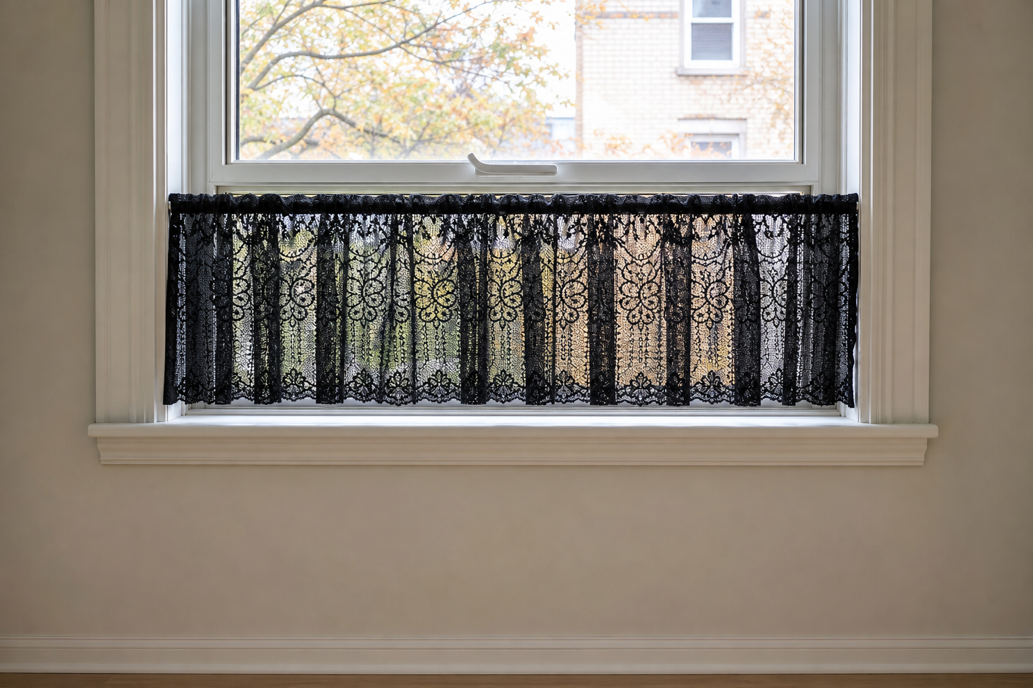 Short black lace cafe curtain across the lower third of an apartment window