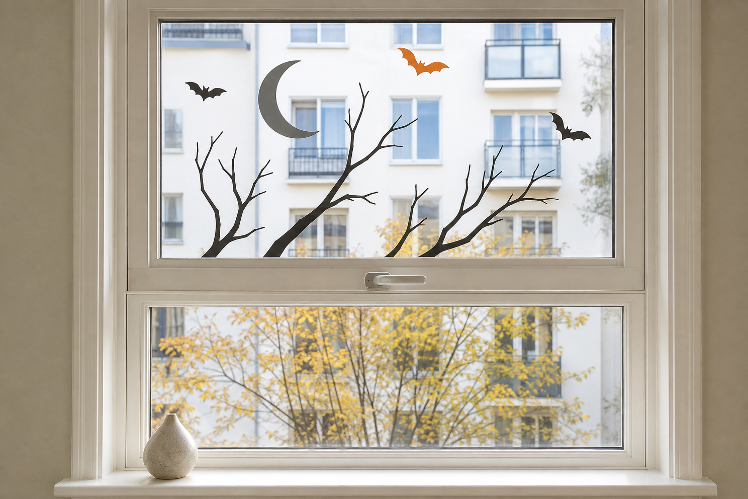 Crescent moon, bare branches, and bats arranged as a restrained upper-pane cling scene