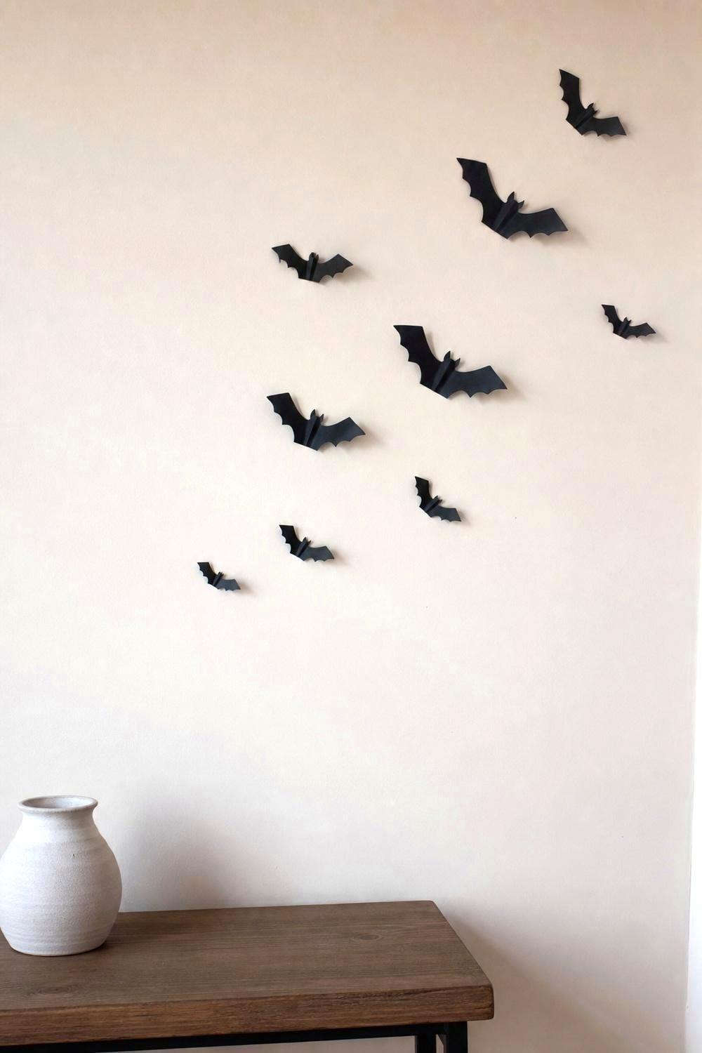 Black 3D bats in graduated sizes scattered up a plain painted wall