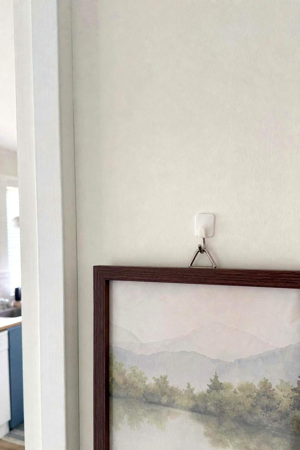 A small hidden patch of peel-and-stick wallpaper being tested on a satin-painted rental wall