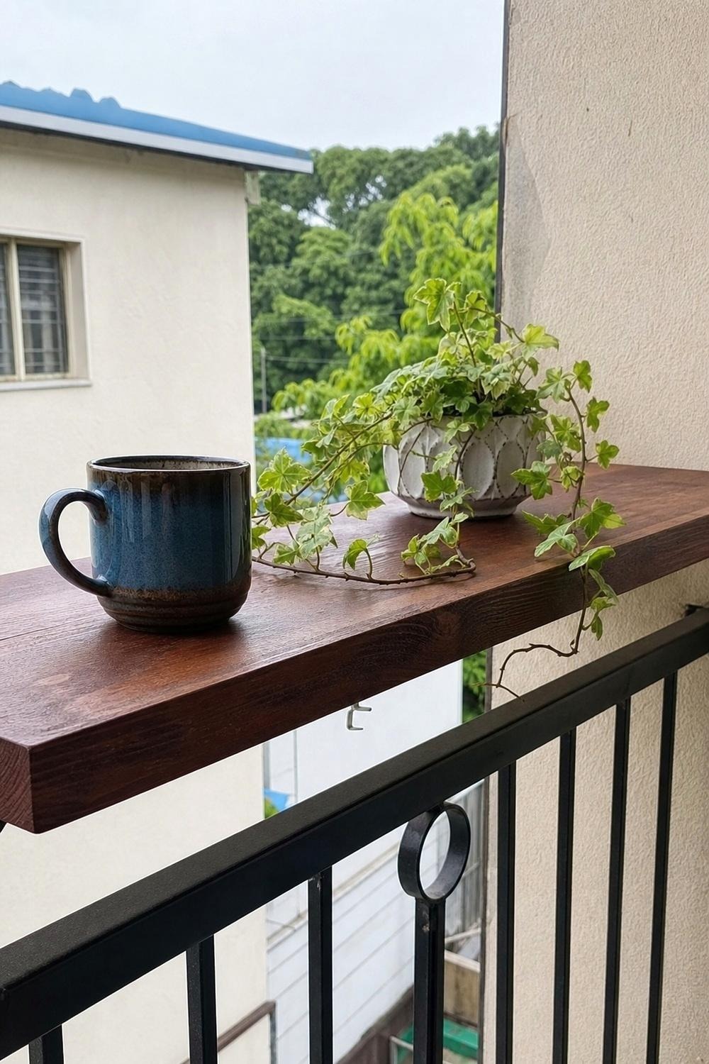 Close-up of a hook-on bracket mount clamped over a balcony rail cap