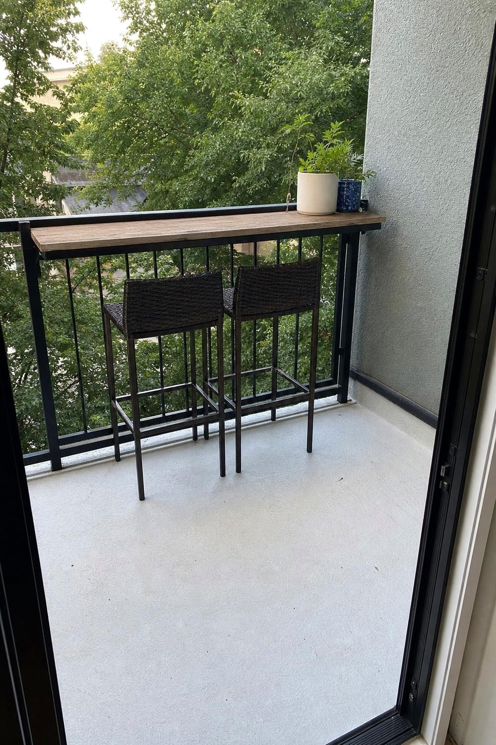 Finished small balcony bar setup with two stools, a rail counter, and a drink in the evening light